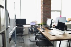 A modern office with wood desks and brick details